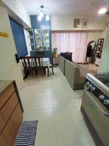ein Wohnzimmer mit Sofa und Tisch in der Unterkunft Family-Ready Skyline Retreat near BGC with Free Parking in Manila