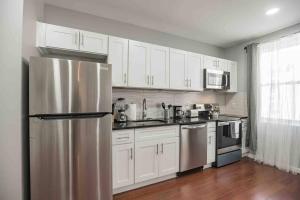 a kitchen with white cabinets and a stainless steel refrigerator at Large and Sunny 1BR - Center City - Sleeps 4 in Philadelphia