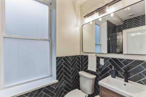 a bathroom with a toilet and a sink and a mirror at Large Studio w 2 Beds and Balcony (C) in Philadelphia +7 photos