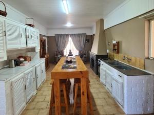 une grande cuisine avec une table en bois. dans l'établissement Nawi Unit 3, à Potchefstroom