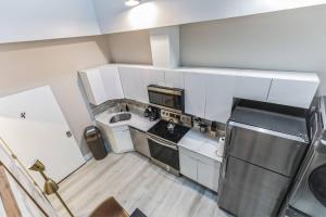 a small kitchen with a sink and a refrigerator at Bi-Level 2BR Loft in Old City in Philadelphia +3 photos