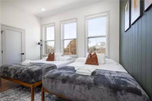 two beds in a room with two windows at 2BR - Across from Fairmount Park -10 mins to DT in Philadelphia