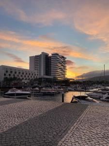 a group of boats in a marina with a building at Tróia Resort - Paradise in Troia