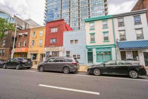 3 voitures garées sur le côté d'une rue de la ville dans l'établissement BRAND NEW Modern 2BR - Heart of Center City, à Philadelphie
