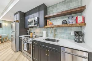 - une cuisine avec des placards noirs et un évier dans l'établissement Bi-Level 2BR w Rooftop - Sleeps 12 - 10 min to DT, à Philadelphie