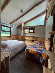 a bedroom with a bed and two windows at cabaña eco las torres del simpson aysen patagonia in Puerto Dunn