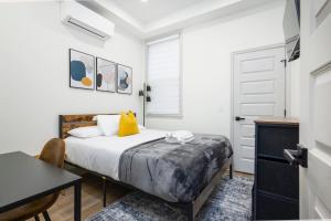 Un dormitorio con una cama, un escritorio y una mesa. en 1BR Across from Fairmount Park - 10 mins to DT (E), en Filadelfia