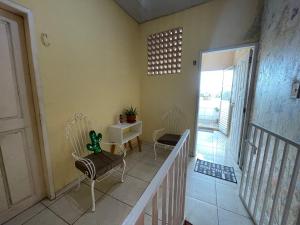 Habitación con 2 sillas, mesa y escalera. en Suítes COP30 Belém Lofts com entrada privativa, en Belém