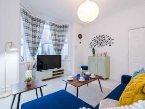 een woonkamer met een blauwe bank en een tv bij Sleep7, Pool Table, TTennis, Free Parking, 3BR in Manchester