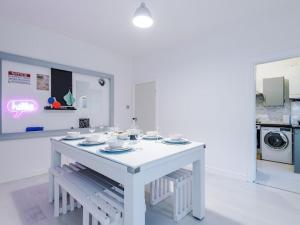 een keuken met een witte tafel met borden erop bij Sleep7, Pool Table, TTennis, Free Parking, 3BR in Manchester