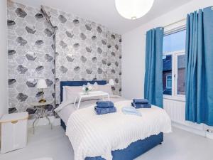 een slaapkamer met een bed met blauwe kussens erop bij Sleep7, Pool Table, TTennis, Free Parking, 3BR in Manchester