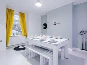 een witte tafel in een witte kamer met gele gordijnen bij Sleep7, Pool Table, TTennis, Free Parking, 3BR in Manchester +30 foto's