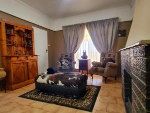 - un salon avec un canapé, une chaise et une fenêtre dans l'établissement Nawi Unit 3, à Potchefstroom