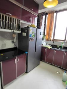 une cuisine avec un réfrigérateur, des armoires violettes et une fenêtre dans l'établissement Primenest - My Dream 3 bed room apartment near African Union, à Addis-Abeba