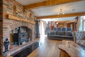 a living room with a brick fireplace and a couch at The Barn & The Log Cabin, Sleeps 12, 2 Hot Tubs, Near Durham & Bishop Auckland in Durham +56 photos