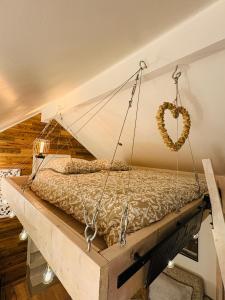 een bedschommel met een hart aan de muur bij Le Perchoir " Une nuit suspendu dans le temps" in Chessy