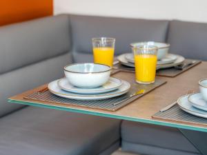 a table with plates and glasses of orange juice at ST Helens 5 beds 3bath Fast WIFI Parking in Saint Helens +32 photos