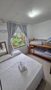 a bedroom with two beds and a window at Caioba com excelente localização in Matinhos
