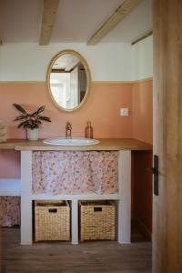un bagno con lavandino e specchio di Gîte à la ferme - Animaux et séjour ressourçant a Les Hays
