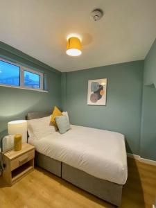 a bedroom with a bed in a blue wall at Location! Location! City Centre Townhouse Sleeps 6 in Galway