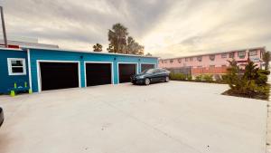 デイトナビーチにあるWavecrest Retreat Near Strip & Beachの青い建物の隣の駐車場に停められた車