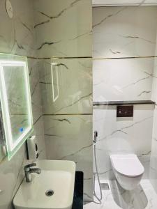 Un baño blanco con lavabo e inodoro. en Hotel maharaja 2, en Udaipur