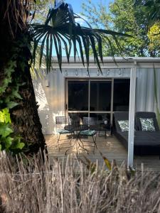 a patio with a bed and a table and chairs at Tropical Garden Retreat in Napier