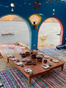 a table with cupcakes on it with a view of the water at nobiano hostel in Aswân Reservoir Colony