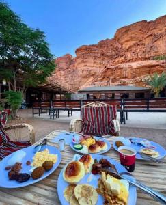 a table with plates of breakfast food on it at RUM SUN SET VIEW BUBBLE lUXURY CAMP in Wadi Rum