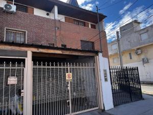 a gate in front of a brick building at Genoveva, descanso y calma in Neuquén