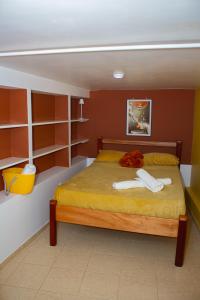 a bedroom with a large bed with orange walls and shelves at Studio City Center in Mindelo