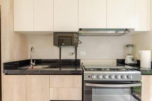 una cucina con fornelli e lavello di NOK Amazing 1 BR by Vistacana Rentals a Pueblo Bávaro Altre 20 foto