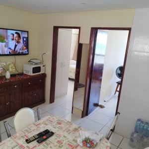 a dining room with a table and a tv on a wall at Frente para Mar de água cristalinas in Itanhaém +53 photos