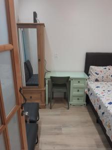 - une chambre avec un bureau, un lit et un miroir dans l'établissement Studio em vila centenária em Copacabana, à Rio de Janeiro
