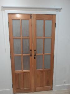 une armoire en bois avec des portes vitrées dans une pièce dans l'établissement Studio em vila centenária em Copacabana, à Rio de Janeiro 26 autres photos