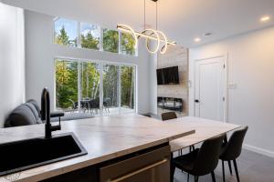 a kitchen with a large window and a table with chairs at Mini-chalet #4 Chute-à-Bull Saint-Côme in Saint Come
