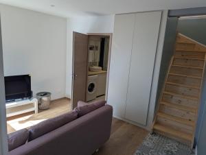 a living room with a couch and a television at Le Triplex maison de ville rénovée in Wasselonne