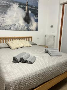 a bed with two towels and a lighthouse on it at Dreams Home in Locate di Triulzi