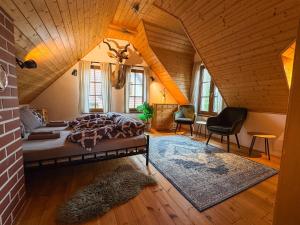 a bedroom with a bed and chairs in a attic at Stylová Lodge s vlastním koupáním, krbem & Netflix in Varvažov
