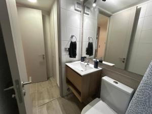 Un baño con inodoro, lavabo y espejo. en 1H1B I Movistar Arena I Con Estacionamiento, en Santiago