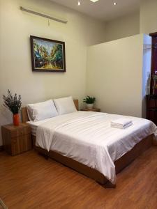 a bedroom with a large bed with a painting on the wall at Charm Home 2 in Hanoi