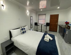 a bedroom with a large white bed and a kitchen at The Palms Guest House in Johannesburg +110 photos