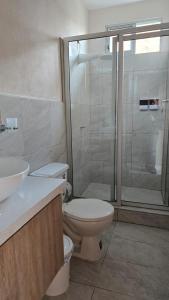 Un baño con inodoro y ducha de cristal. en Departamento centro Sucúa, en Sucúa