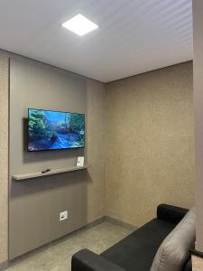 オリンピアにあるFlat Berlim Piscina e Confortoの壁に薄型テレビが取り付けられたリビングルーム