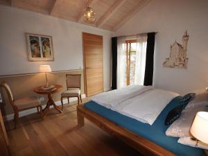 a bedroom with a bed and a table and a window at Haus Sonnenau in Pfronten