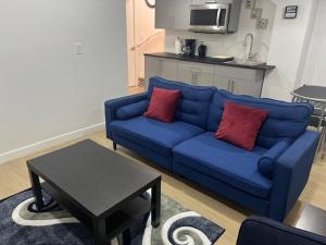 a blue couch with two red pillows in a living room at Bliss Haven in Winnipeg +33 photos