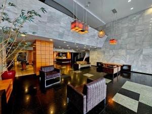a living room with couches and chairs and a lobby at Hotel Santoni in Guarapuava