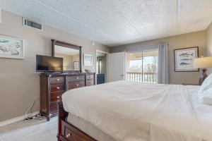 een slaapkamer met een bed, een tv en een spiegel bij Marlin Arms Condominiums #9 in South Padre Island +19 foto's