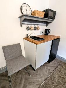 cocina con escritorio y reloj en la pared en Private Ensuite Room, en Nantwich