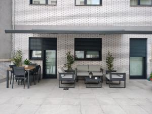 a patio with tables and chairs in front of a brick building at Terrazas de Argandona in Gijón
